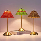 Cordless rechargeable table lamps in green, red and brown, glowing in the evening