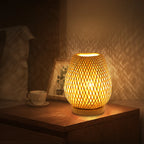 Cocoon woven bamboo table lamp glowing at night – Maison Liane
