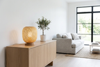 Bambou woven bamboo table lamp on a white oak sideboard in a bright Scandinavian living room