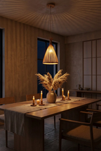 Hana Cone bamboo pendant light glowing at night above a candlelit oak dining table